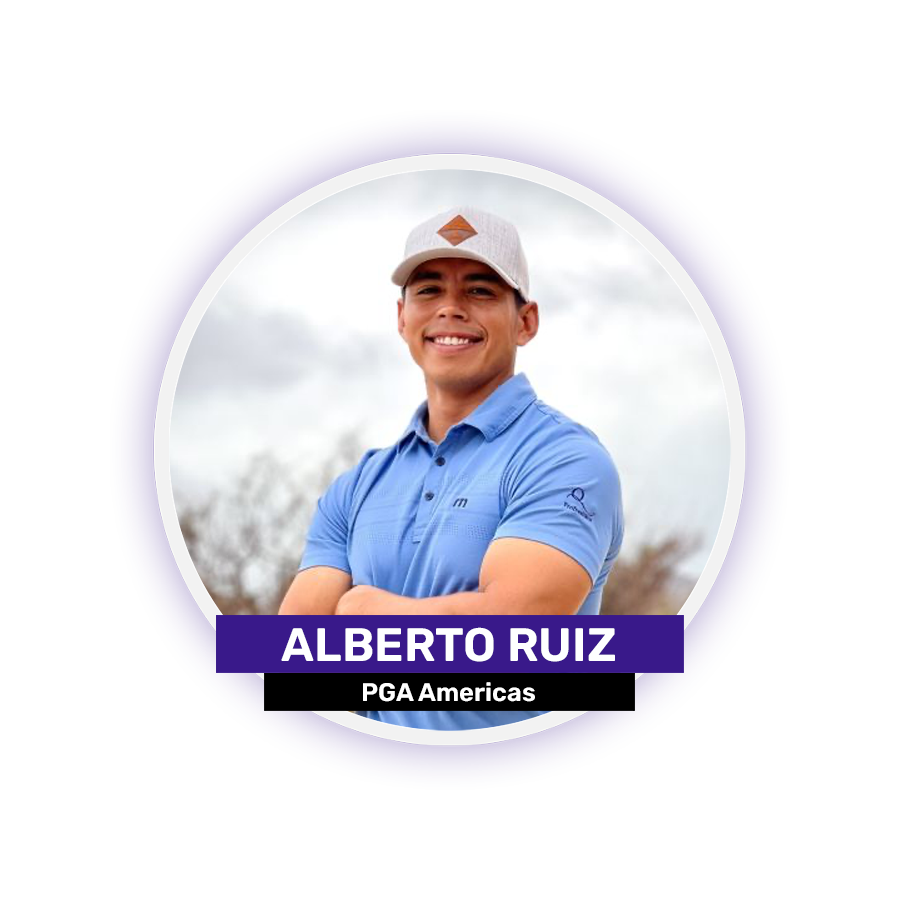 A person in a blue shirt and baseball cap is smiling with arms crossed.